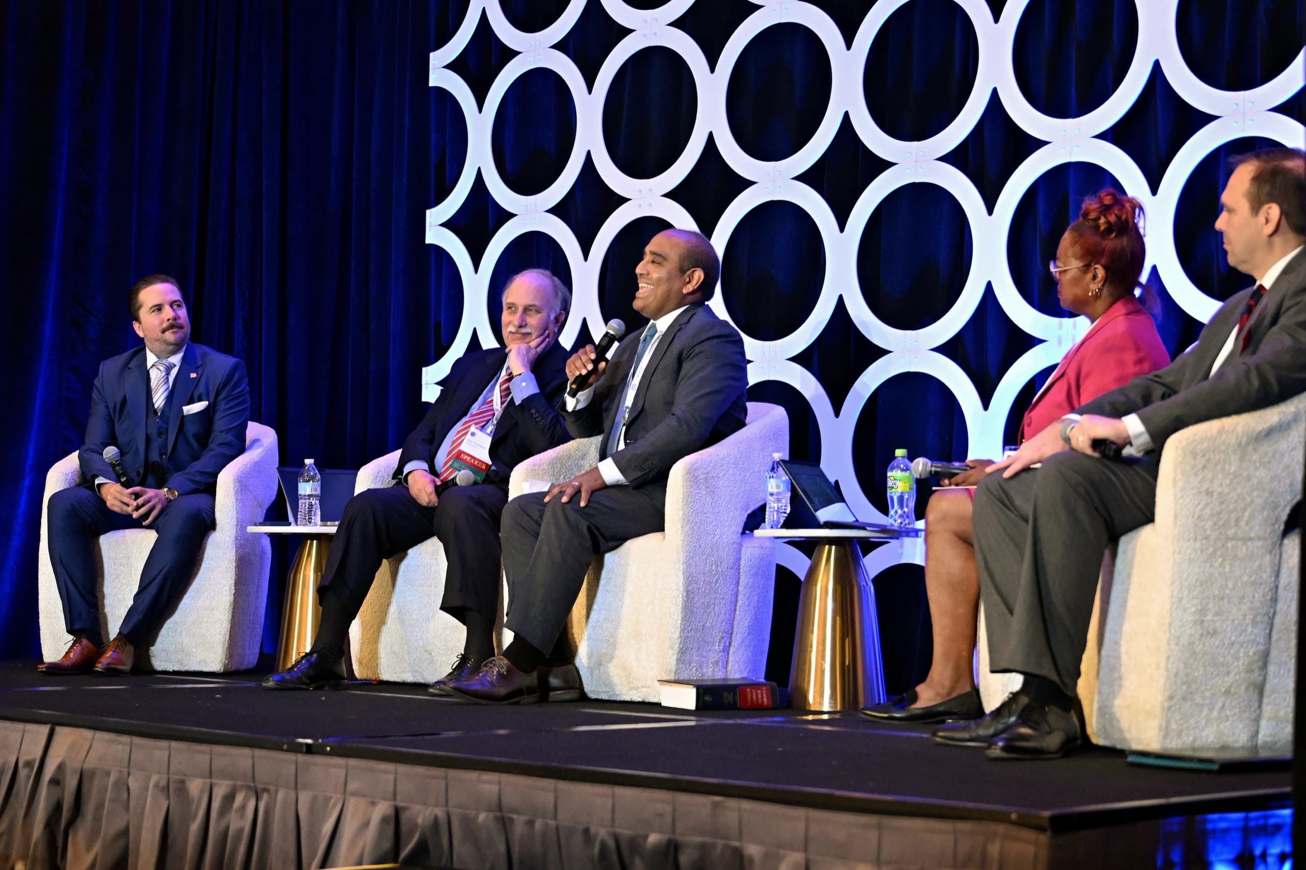 Conference panel sharing a laugh on stage — corporate event photography